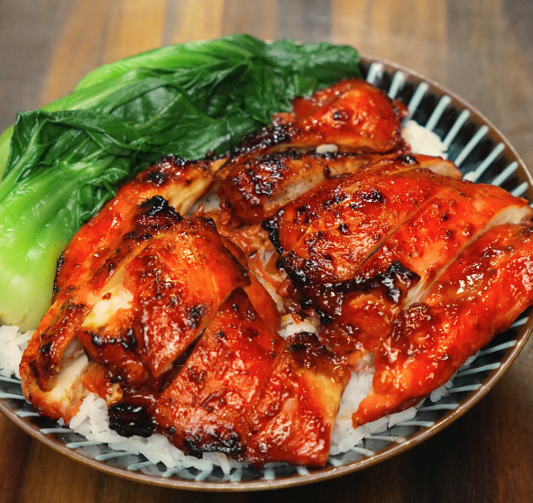 Close-up of Char Siu Chicken served over steamed white rice with bok choy. Juicy, caramelized chicken thighs with a sweet, savory glaze make this easy Asian recipe perfect for a 30-minute dinner, meal prep, or healthy weeknight meal. Air fryer and oven-friendly.