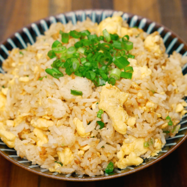 homemade egg fried rice in bowl with green onion garnish – healthy takeout-style meal