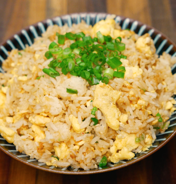 homemade egg fried rice in bowl with green onion garnish – healthy takeout-style meal