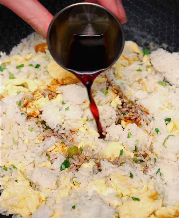 adding soy sauce to egg fried rice – classic Chinese fried rice flavor