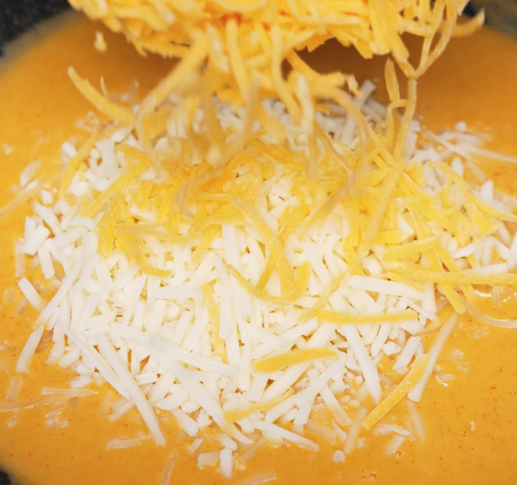 A generous amount of shredded cheddar and mozzarella cheese is added into the gochujang-infused sauce to create a rich and gooey cheese blend.