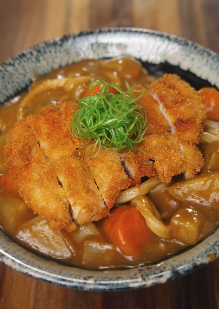 Final bowl of Chicken Katsu Curry Udon featuring crispy panko-fried chicken over rich Japanese curry and udon noodles, garnished with scallions.