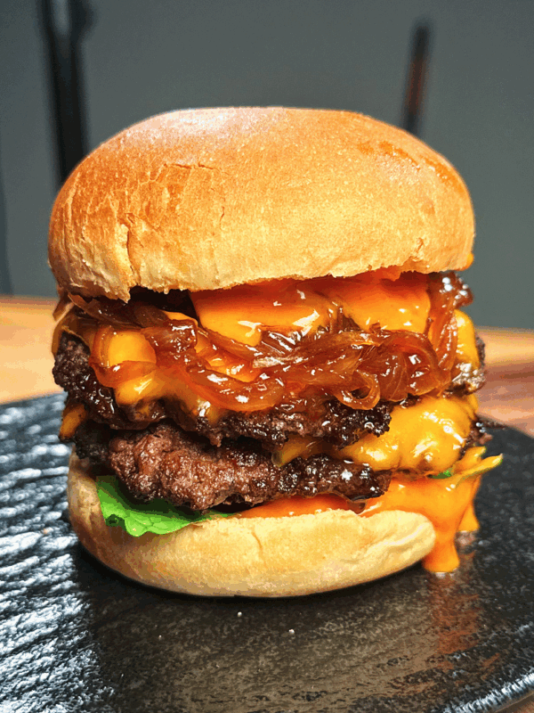 Stacking caramelized onions, cheesy patties, and spicy mayo inside toasted burger buns, bringing together all the rich layers of the Asian Smash Burger.