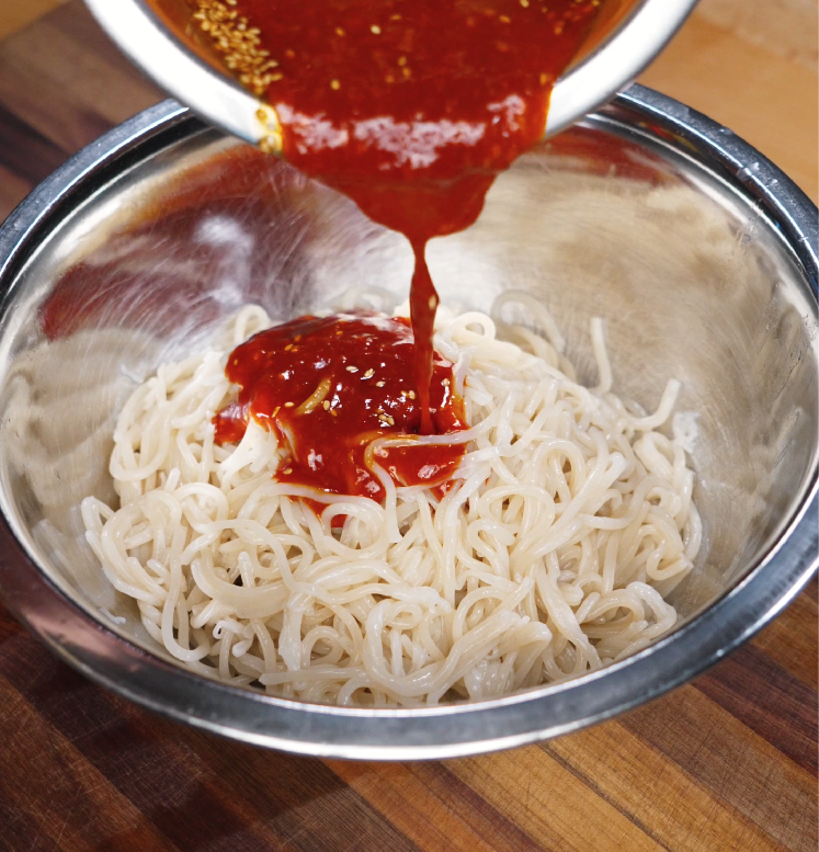 pouring-spicy-sauce-over-cooked-jjolmyeon.jpg
