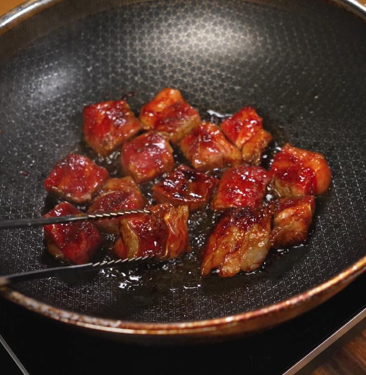 Beef cubes sizzling in a nonstick skillet as they develop a caramelized crust, locking in the savory marinade and building flavor in this shaking beef dish.