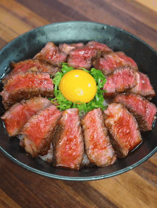 Final hero shot of steak rice bowl featuring seared beef, raw egg yolk, scallions, and glossy glaze served in a rustic bowl.