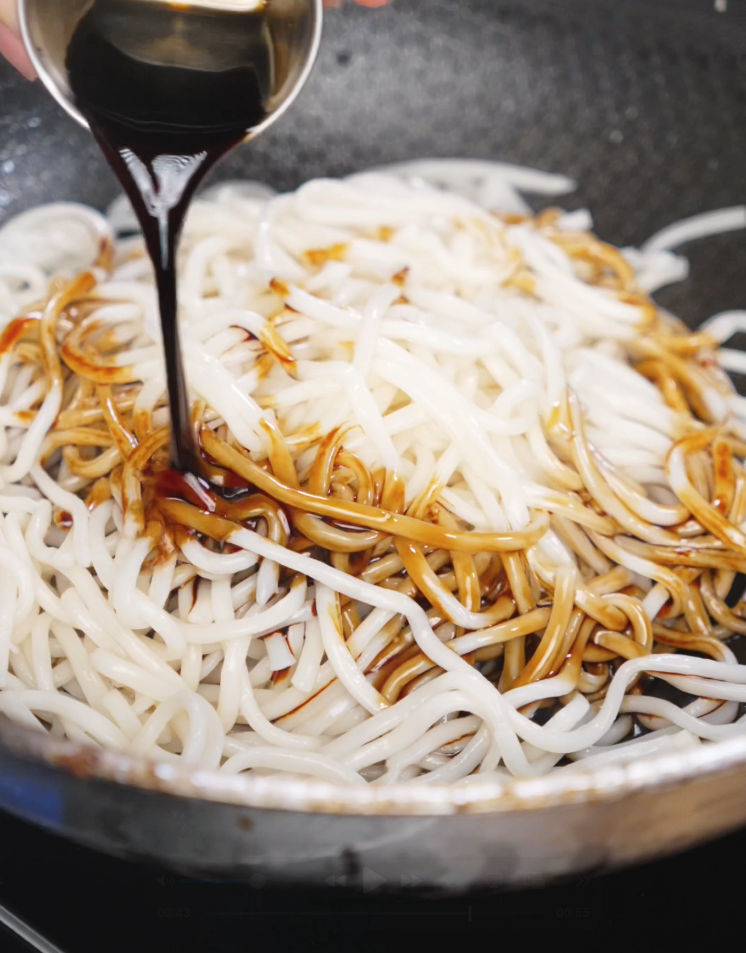 The second half of garlic is cooked in oil before noodles are tossed in with light and dark soy sauce. The noodles absorb the garlicky soy glaze.