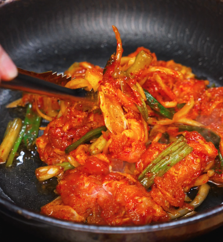 Marinated pork, onions, and scallions sizzle in a hot pan as they caramelize and cook down into a thick, flavorful glaze.