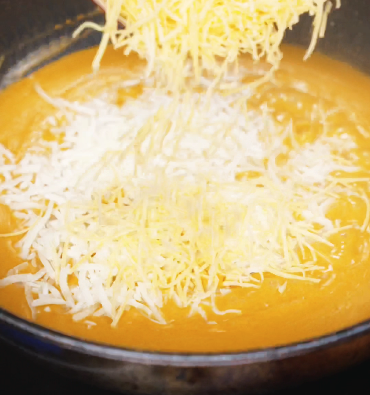 Shredded cheddar and mozzarella are added to the thickened gochujang sauce, slowly melting into a velvety, spicy cheese mixture.
