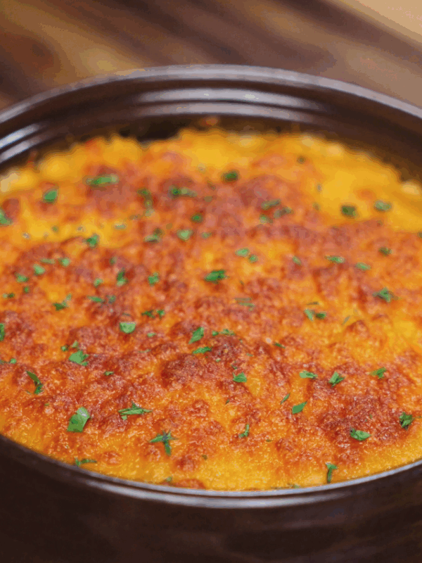 The baked gochujang mac and cheese emerges golden brown and bubbling, with flecks of parsley adding a pop of green.