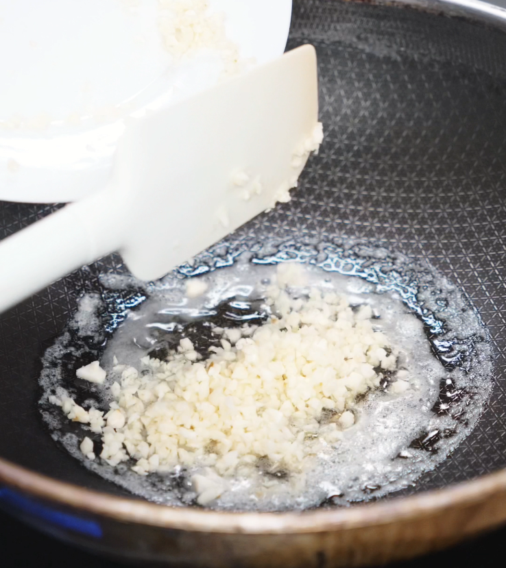 Freshly minced garlic is added to sizzling oil in a nonstick pan, releasing its fragrance for the flavorful sauce base.