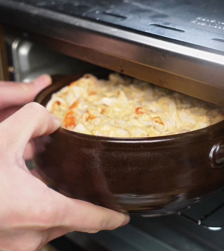 The assembled sushi bake is placed into the oven to broil until bubbly and golden brown.