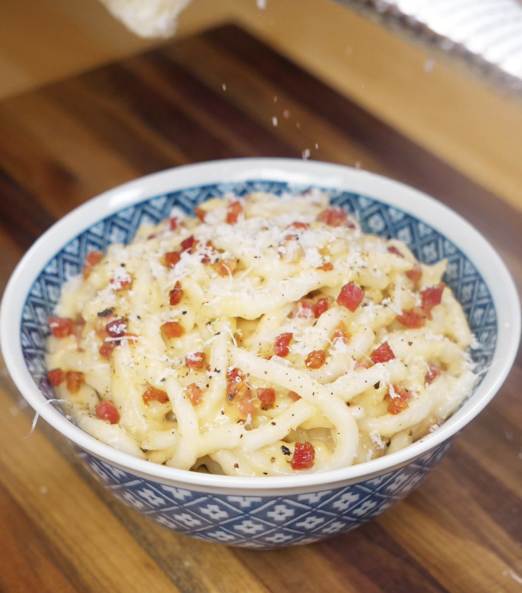 Freshly grated parmesan cheese is sprinkled over the top of the finished carbonara udon for extra creaminess.