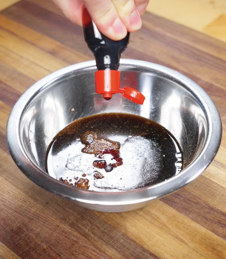 A bowl of soy sauce, hoisin, honey, garlic, and seasonings being combined to make the char siu marinade.