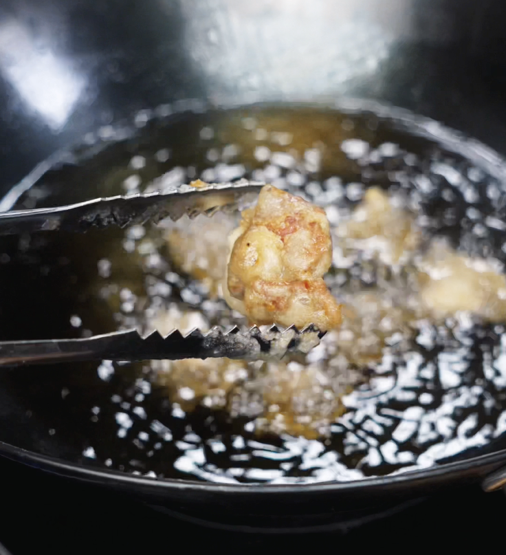 Fried chicken pieces are lowered back into the oil for a second fry at 400°F to get extra golden and crunchy.