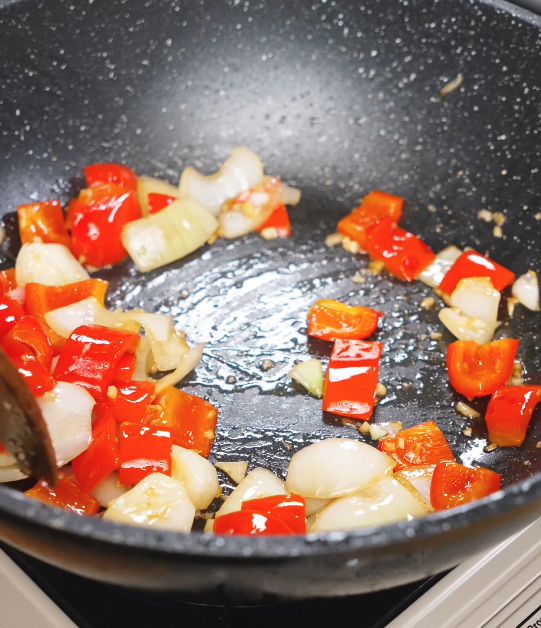 Onions and bell peppers saut&eacute;ing in the pan with oil until slightly softened and fragrant for black pepper beef.