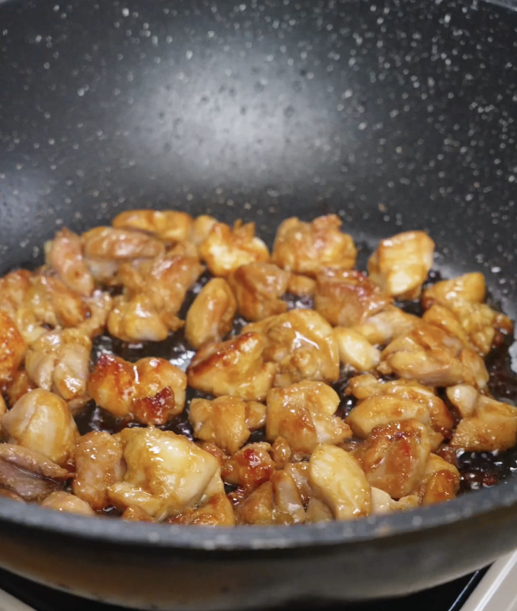 Bite-sized pieces of marinated chicken thighs cooking in a pan until lightly caramelized and golden brown for chicken bibimbap.
