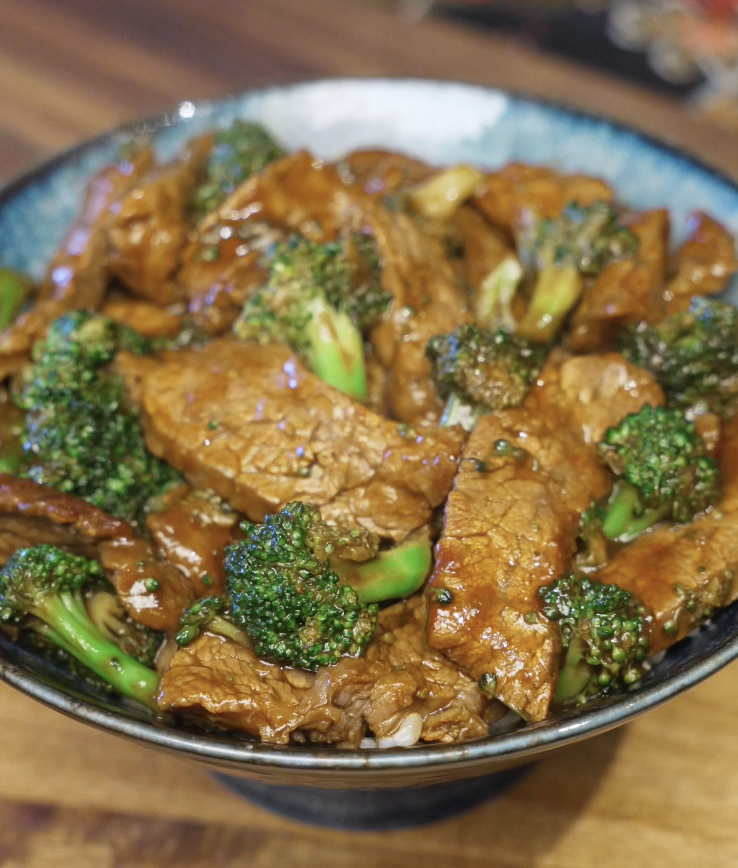 Finished beef and broccoli coated in a glossy brown sauce, with tender beef slices and crisp broccoli florets.