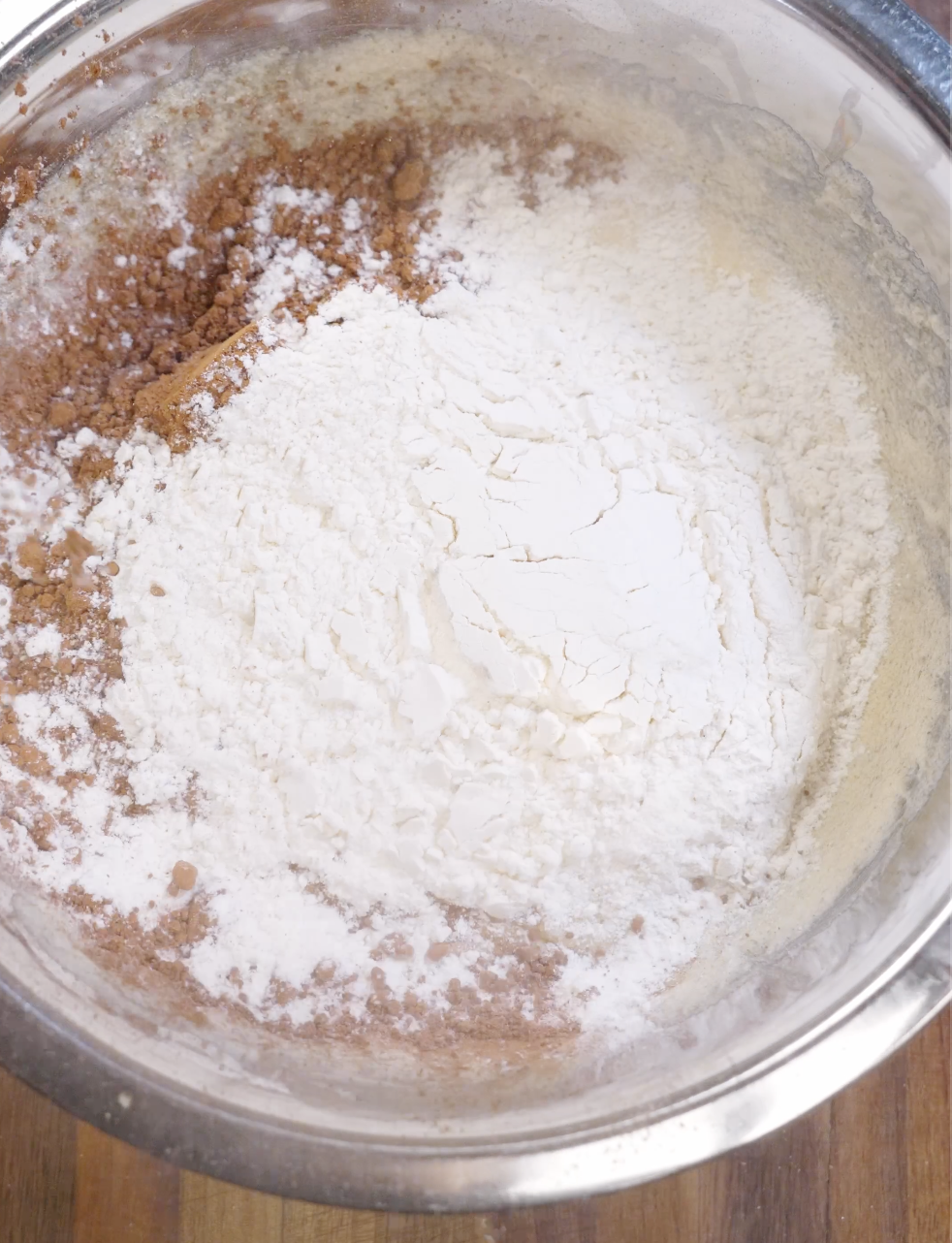 Cocoa powder, flour, baking powder, and salt added on top of glossy brownie cookie batter before gently folding to maintain a fudgy texture.