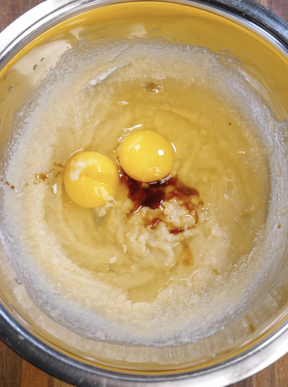Eggs and vanilla extract added to the glossy butter and sugar mixture before continued whisking to aerate the batter for shiny brownie cookie surfaces.