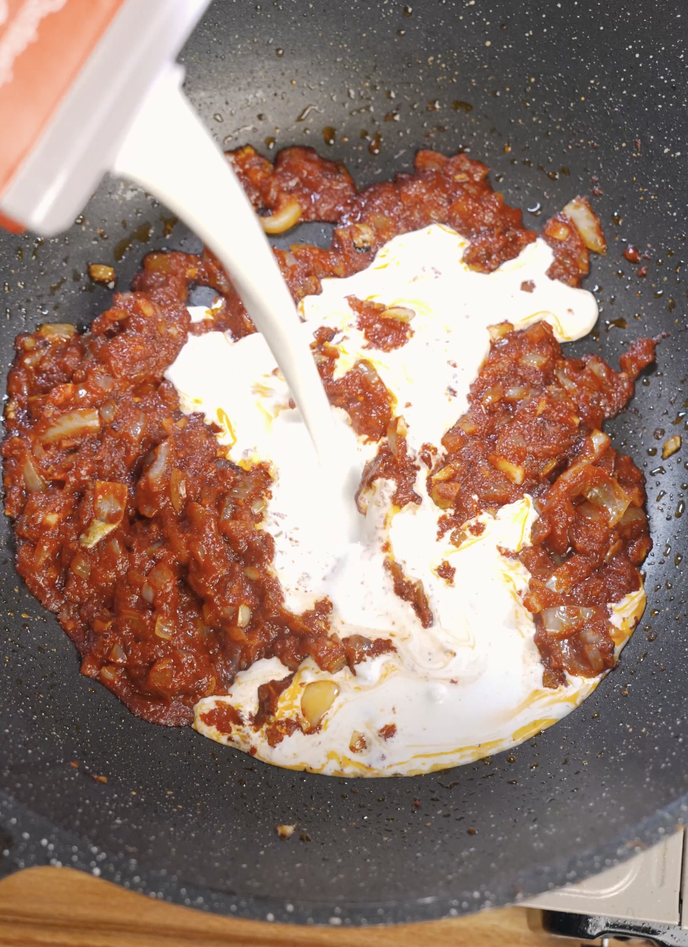 Heavy cream poured into reduced tomato vodka sauce, transforming it into a smooth and creamy vodka pasta sauce.