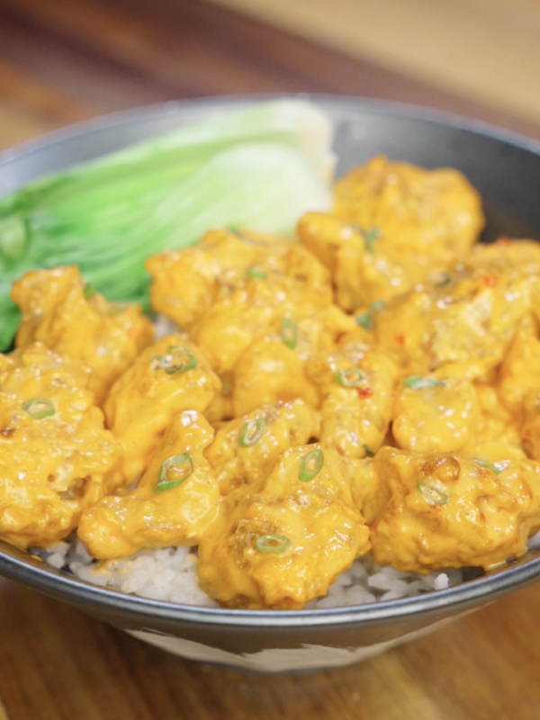 Creamy sweet and spicy bang bang chicken served over steamed white rice with tender bok choy and sliced scallions for a quick high protein Asian dinner.