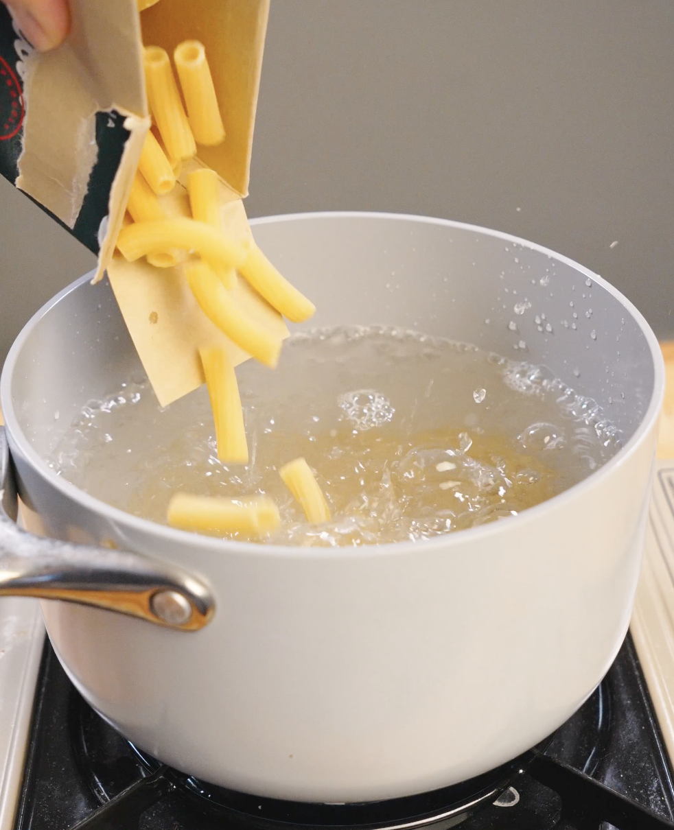 Dry rigatoni pasta dropped into a pot of boiling salted water, cooked just before al dente for vodka pasta.