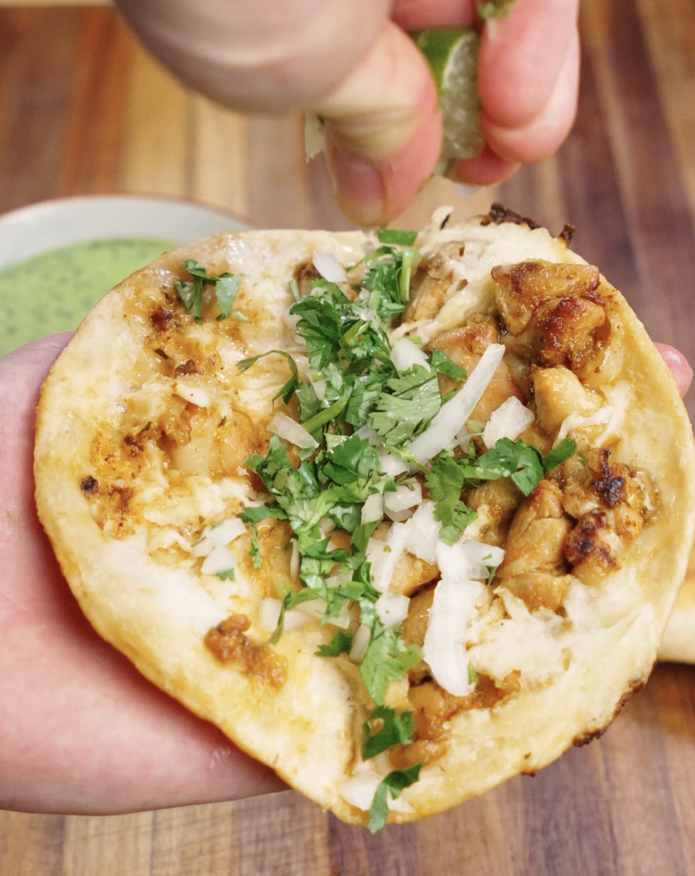 Fresh chopped cilantro and finely diced onion added on top of crispy chicken tacos, finished with a squeeze of lime for brightness and flavor.