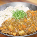 Finished bowl of Japanese ground beef curry made with tender ground beef, carrots, potatoes, and a rich curry sauce, served with fluffy white rice and topped with sliced scallions.