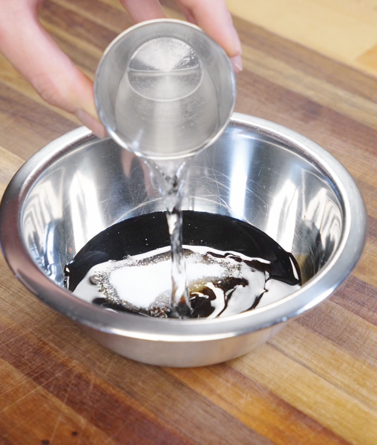 Dark soy sauce, light soy sauce, oyster sauce, sesame oil, sugar, and water being combined in a bowl to create the savory umami stir fry sauce.