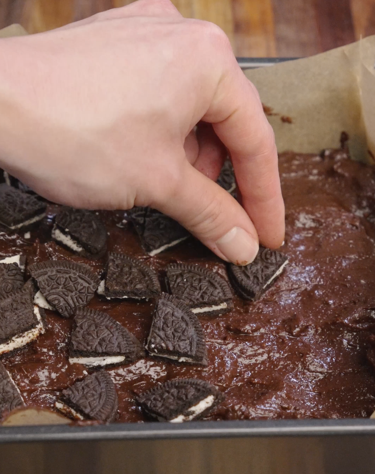 Oreo cookie pieces pressed into the surface of brownie batter before baking, creating a signature crackly Oreo-studded top.