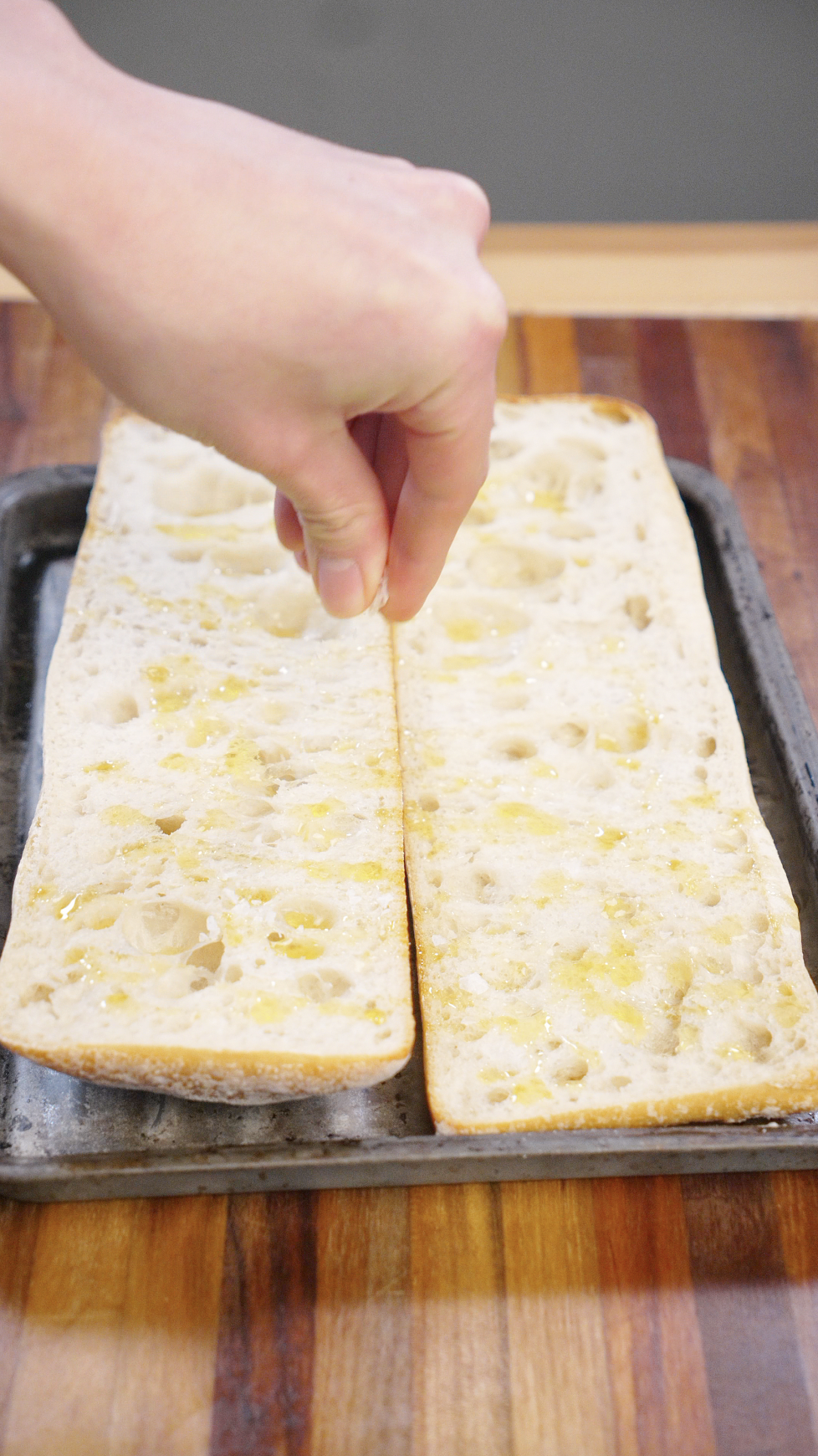 Ciabatta bread halves brushed with olive oil and toasted on a hot pan until golden and crisp for a turkey pesto sandwich.