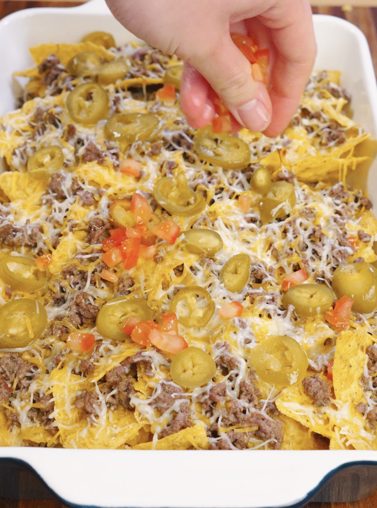 Adding fresh vegetables to Sheet Pan Nachos in order to give it good balance and flavor.