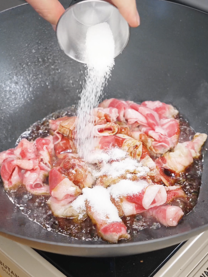 Thinly sliced beef cooking in a pan with soy sauce and seasonings for beef bibimbap recipe.
