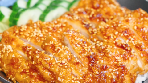 Sliced crispy garlic chicken glazed in soy garlic sauce and topped with sesame seeds served over steamed rice with sliced cucumbers.