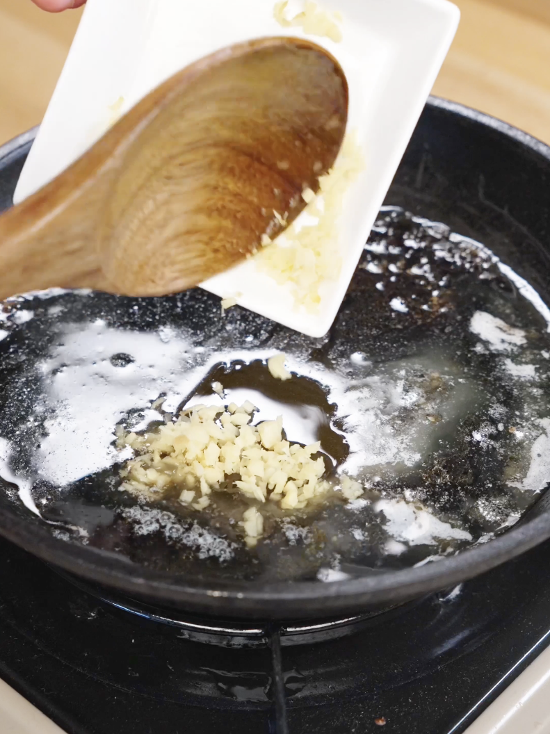 Minced ginger being added to a pan with melted butter and sauce base for the Honey Butter Chicken Tenders Recipe.