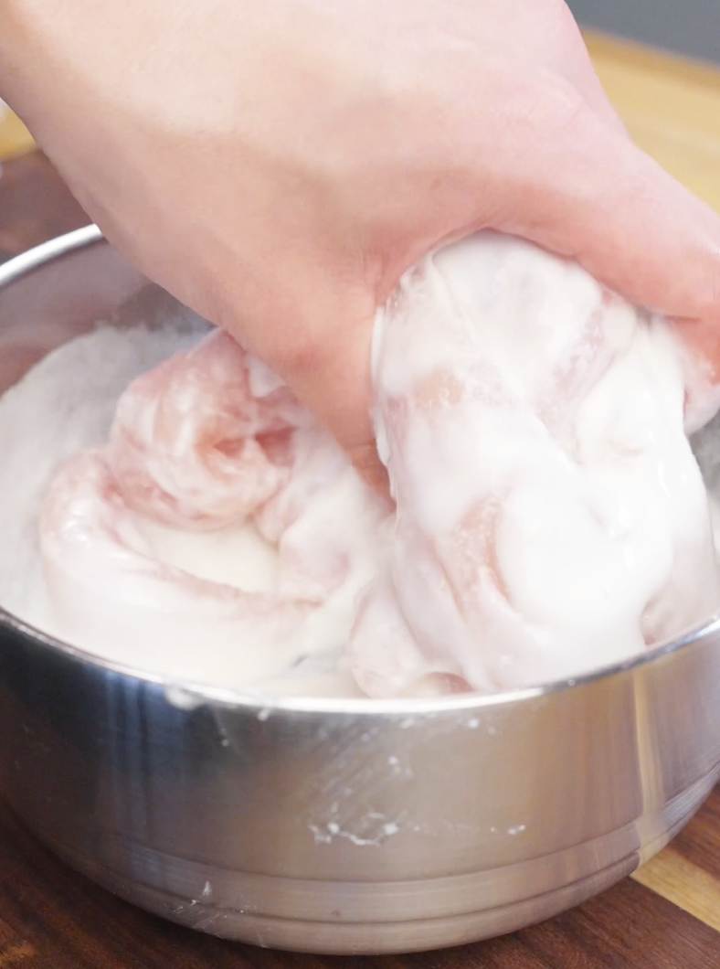 Hand coating raw chicken tenderloins in a smooth rice flour and potato starch batter for the Honey Butter Chicken Tenders Recipe.