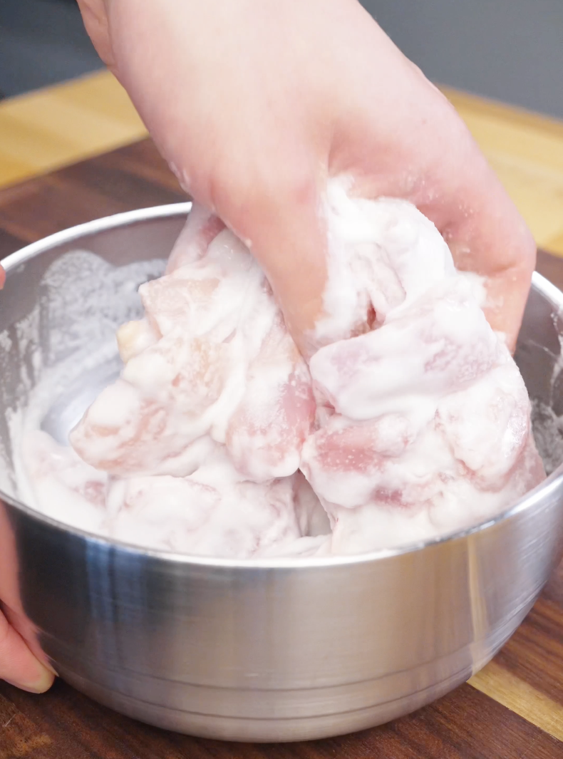 Raw chicken pieces being fully coated in a light batter mixture for the Honey Butter Fried Chicken Recipe.
