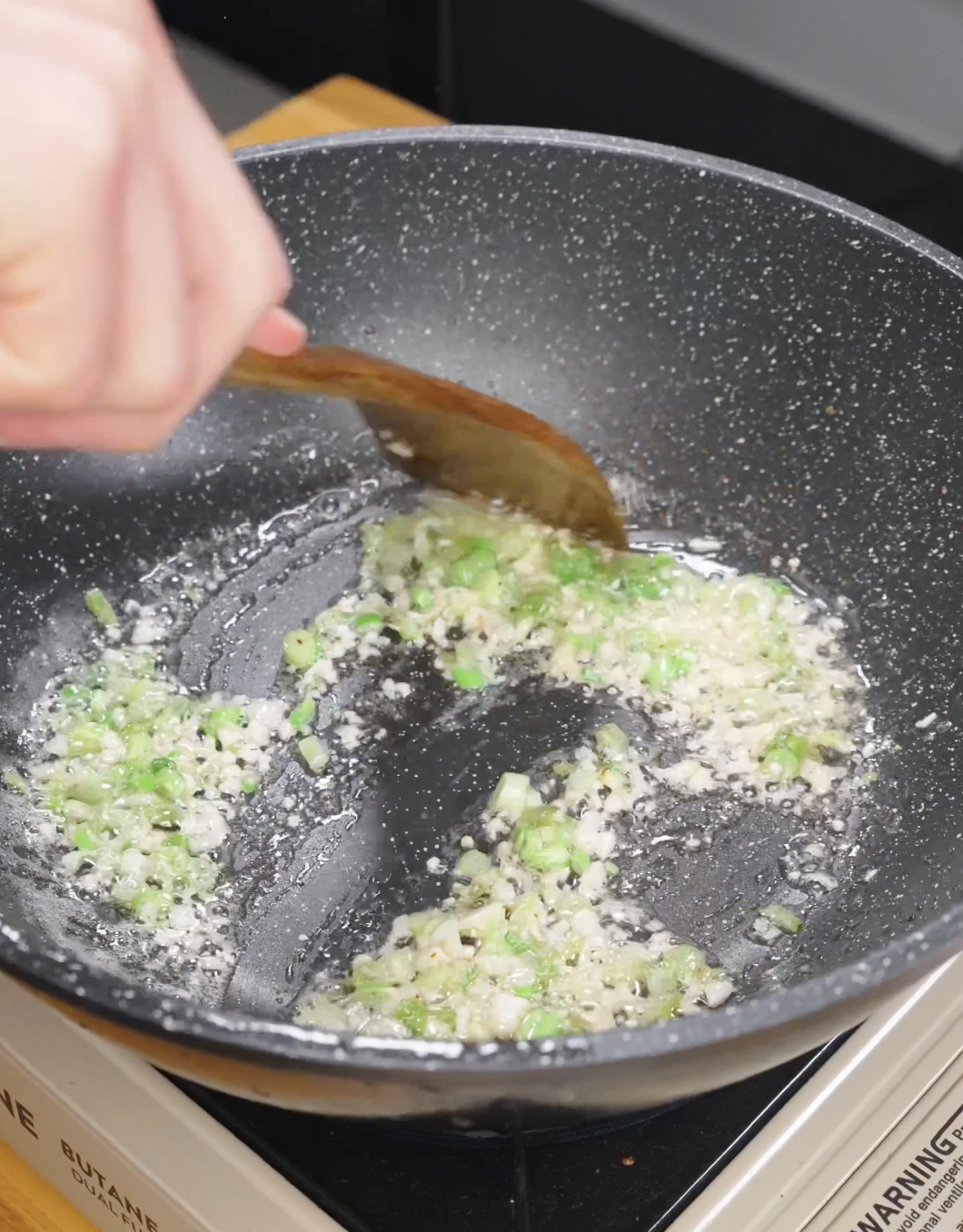 Garlic and scallions saut&eacute;ing in bacon fat to build flavor for garlic bacon fried rice.