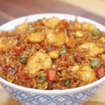 Chicken fried rice served in a bowl with tender chicken, mixed vegetables, and rice coated in a glossy soy-based sauce.