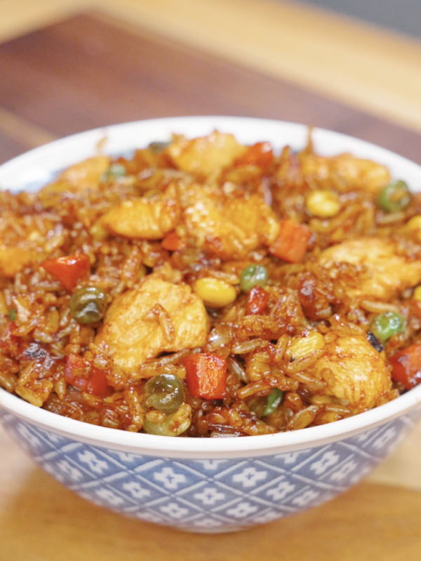 Chicken fried rice served in a bowl with tender chicken, mixed vegetables, and rice coated in a glossy soy-based sauce.