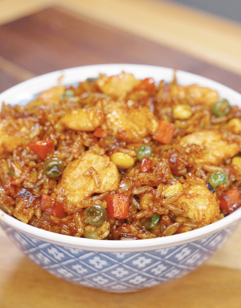 Chicken fried rice served in a bowl with tender chicken, mixed vegetables, and rice coated in a glossy soy-based sauce.