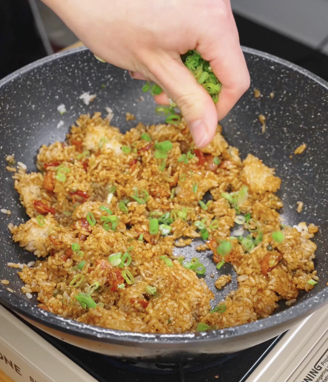 Scallion greens being added to Garlic Bacon Fried Rice to add balance to the richness and for colorl