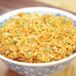 Finished bowl of Creamy Chili Oil Noodles Recipe topped with sesame seeds and scallions, featuring a rich creamy sauce infused with chili oil and soy sauce.