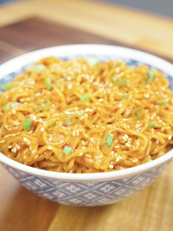 Finished bowl of Creamy Chili Oil Noodles Recipe topped with sesame seeds and scallions, featuring a rich creamy sauce infused with chili oil and soy sauce.