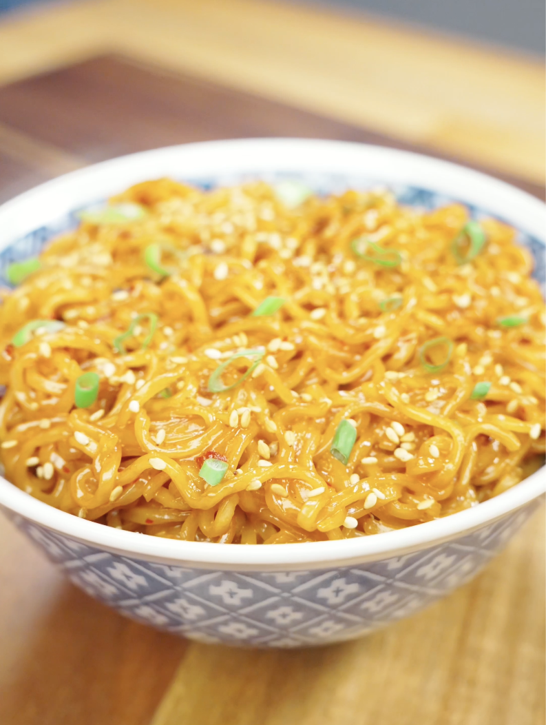 Finished bowl of Creamy Chili Oil Noodles Recipe topped with sesame seeds and scallions, featuring a rich creamy sauce infused with chili oil and soy sauce.