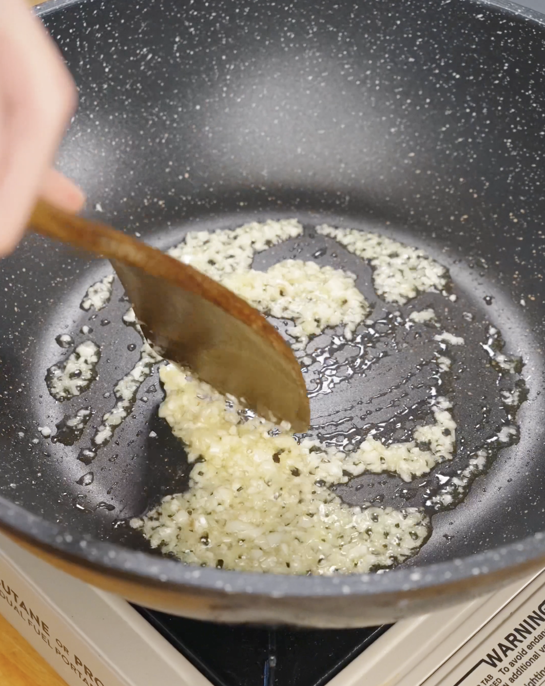 Minced garlic and ginger sautéing in oil in a skillet to build aromatic flavor for homemade Sticky Ground Beef Recipe.