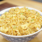 Bowl of Egg Fried Rice topped with fresh scallions and made with fluffy scrambled eggs, garlic, and seasoned day-old rice. This easy one-pan rice dish is perfect for weeknight dinners and meal prep.