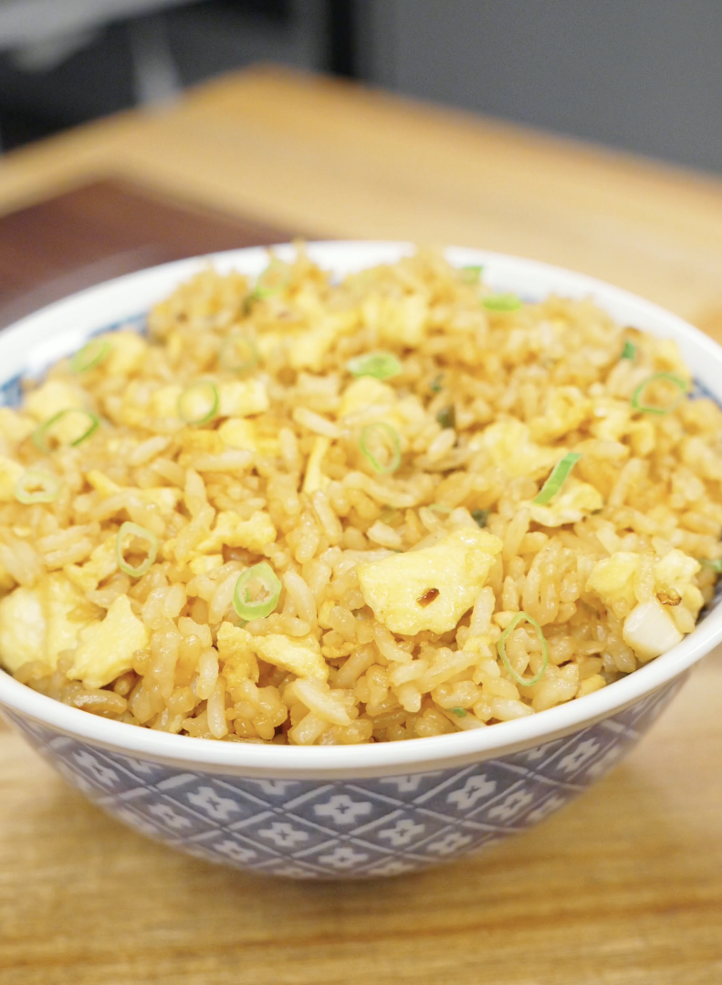 Bowl of Egg Fried Rice topped with fresh scallions and made with fluffy scrambled eggs, garlic, and seasoned day-old rice. This easy one-pan rice dish is perfect for weeknight dinners and meal prep.