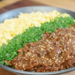 Japanese Ground Beef Egg Bowl Recipe served with fluffy scrambled eggs, chopped chives, sesame seeds, and savory glazed ground beef over rice.